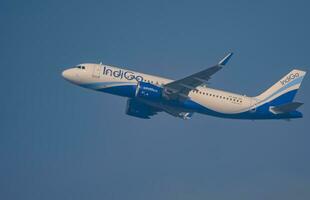 nieuw Delhi, Indië, december 25 2023 - indigo luchtbus a320 nemen uit van indra Gandhi Internationale luchthaven Delhi, indigo huiselijk vliegtuig vliegend in de blauw lucht gedurende dag tijd foto