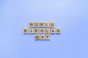 Aan maart 30, wereld bipolair dag, een minimalistisch banier met een opschrift in houten brieven foto