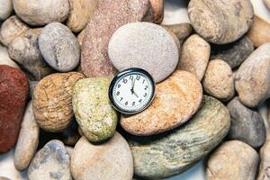 klok met tijd Aan stenen voor de concept van ontspanning of in beweging vooruit en motivatie. foto