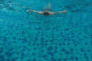 top visie van Mens zwemmen voorkant kruipen in blauw water foto