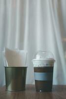 dichtbij omhoog plastic glas van bevroren mokka koffie bekroond met zacht melk schuim foto