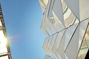 abstract detailopname van de glas bekleed facade van een modern gebouw gedekt in reflecterende bord glas. architectuur abstract achtergrond. glas muur en facade detail. foto