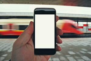 hand- Holding smartphone met metro station achtergrond foto