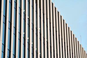 abstract detailopname van de glas bekleed facade van een modern gebouw gedekt in reflecterende bord glas. architectuur abstract achtergrond. glas muur en facade detail. foto