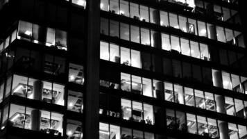 patroon van kantoor gebouwen ramen verlichte Bij nacht. glas architectuur ,zakelijk gebouw Bij nacht - bedrijf concept. zwart en wit. foto