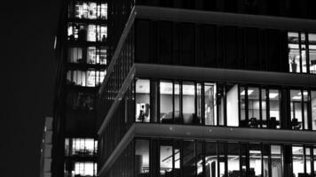 patroon van kantoor gebouwen ramen verlichte Bij nacht. glas architectuur ,zakelijk gebouw Bij nacht - bedrijf concept. zwart en wit. foto