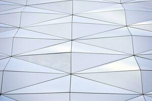 abstract detailopname van de glas bekleed facade van een modern gebouw gedekt in reflecterende bord glas. architectuur abstract achtergrond. glas muur en facade detail. foto