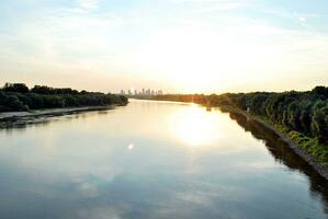 rivier- in de stad in Bij kleurrijk zonsondergang in de achtergrond foto