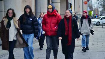 Warschau, Polen. 29 december 2023. mensen van verschillend leeftijden en nationaliteiten wandelen aan de overkant in de stad centrum, winter tijd. mensen Bij de straat. foto