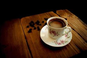 kopje koffie en bonen op een oude houten tafel foto