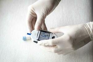 dichtbij omhoog schot van de verpleegster Holding glucometer instrument. gezondheidszorg foto