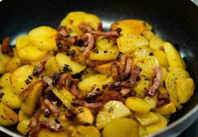 geroosterd aardappelen met spek uien en specerijen foto