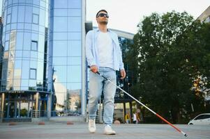 Blind Mens. visueel verminderd Mens met wandelen stok, foto