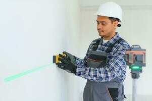 Indisch arbeider maakt reparaties in een appartement foto