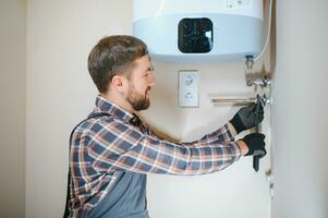 professioneel loodgieter controle een boiler en pijpen, boiler onderhoud concept foto