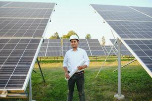 portret van een jong Indisch mannetje ingenieur of architect Bij een zonne- paneel boerderij. de concept van schoon energie foto