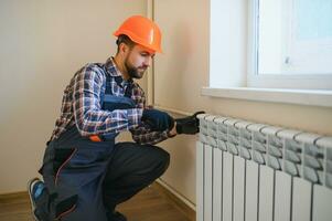 loodgieter Mens is blokkeren reparaties radiatoren van verwarming accu in appartement kraan foto