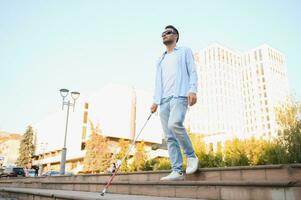 jong knap verblind Mens wandelen met stok in stad- foto