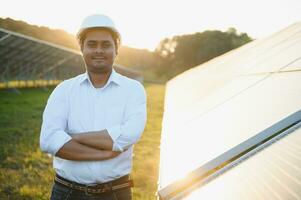 portret van een jong Indisch mannetje ingenieur of architect Bij een zonne- paneel boerderij. de concept van schoon energie foto