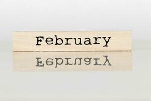 houten kubus met opschrift februari Aan wit achtergrond foto