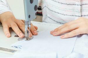 vrouw handen van een meester kleermaker Bij werk, een naaien machine naald- foto