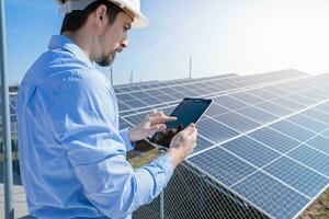 ingenieur werken met een tablet met fotovoltaïsche zonne- paneel systeem fabriek. foto