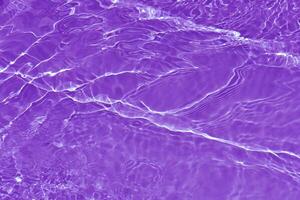 Purper water golven Aan de oppervlakte rimpelingen vervagen. onscherp wazig transparant roze gekleurde Doorzichtig kalmte water oppervlakte structuur met plons en bubbels. water golven met schijnend patroon structuur achtergrond. foto