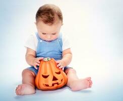 schattig baby jongen met halloween pompoen foto