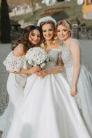 elegant bruidsmeisjes hebben pret met de bruid in natuur en houding op zoek in de camera foto