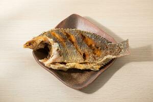 gebakken tilapia met Thaise stijl rijst- Aan een Japans stijl keramisch bord. foto