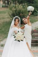 bruiloft foto in natuur. een brunette bruid in een wit lang jurk en haar vriend in een naakt jurk zijn voor de gek houden in de omgeving van samen en glimlachen oprecht. jong Dames. emoties