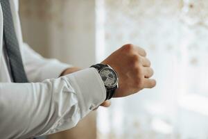 bijgesneden foto van elegant Mens knopen wit shirt. voorkant visie. een elegant horloge. Mannen stijl. mode. bedrijf