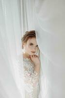mooi bruid. bruiloft kapsel - Aan een wit achtergrond. detailopname portret van een jong prachtig bruid. bruiloft. portret van een mooi bruid verpakt in een sluier foto