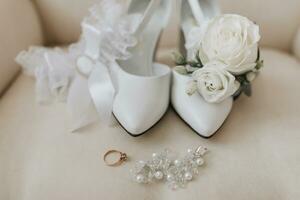 bruids accessoires in licht kleuren, schoenen, oorbellen, bruiloft ring, kousenband en enkel laarzen foto