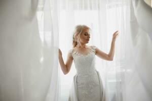 mooie bruid portret bruiloft make-up kapsel, prachtige jonge vrouw in witte jurk thuis. serie. foto