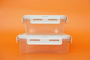 leeg transparant dozen, containers. oranje achtergrond. concept, keukengerei gebruik voor bevat voedsel net zo lunch doos of houden vers van voedsel in koelkast. reinigbaar, herbruikbaar. foto