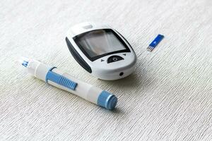 dichtbij omhoog schot van de glucometer instrument Aan de wit oppervlak. gezondheidszorg foto