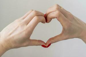 vrouw houdt haar handen in de vorm van de hart net zo een symbool van liefde. valentijnsdag dag foto