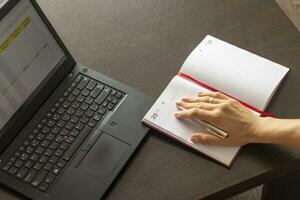 schot van een vrouw werken Aan de laptop tonen een excelleren vel Aan de scherm met bank lening afschrijvingen tafel. financiën foto