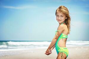 schattig weinig meisje Aan een strand foto