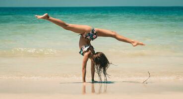 weinig meisje atleet Aan de strand foto