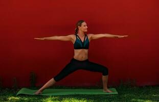 yoga buitenshuis over- rood muur foto