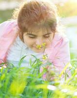 klein meisje genieten van bloemen foto