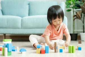 gelukkig Azië kinderen Speel en leren speelgoed- blokken.familie is gelukkig en opgewonden in de huis. dochter hebben pret uitgeven tijd, werkzaamheid, ontwikkeling, iq, gelijk, meditatie, brein, spieren, essentieel vaardigheden. foto