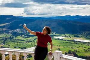 jong vrouw Bij een gezichtspunt over- de mooi sopo vallei Bij de afdeling van cundinamarca in Colombia foto