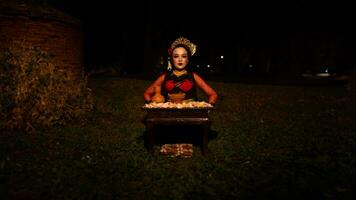 een vrouw danser wie looks mooi in een rood kostuum presteert een ritueel dat straalt uit een aura van schoonheid en zuiverheid foto