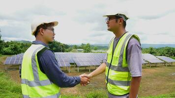 twee Aziatisch ingenieurs beven handen na installeren zonne- panelen . zonne- energie schoon en groen alternatief energie. eenheid en teamwerk. foto