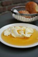 boter room en honing in een kom Aan tafel . foto