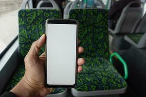 passagier zittend in een bus gebruik makend van zijn telefoon. foto