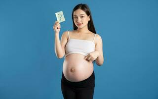 portret van zwanger Aziatisch vrouw, geïsoleerd Aan blauw achtergrond foto